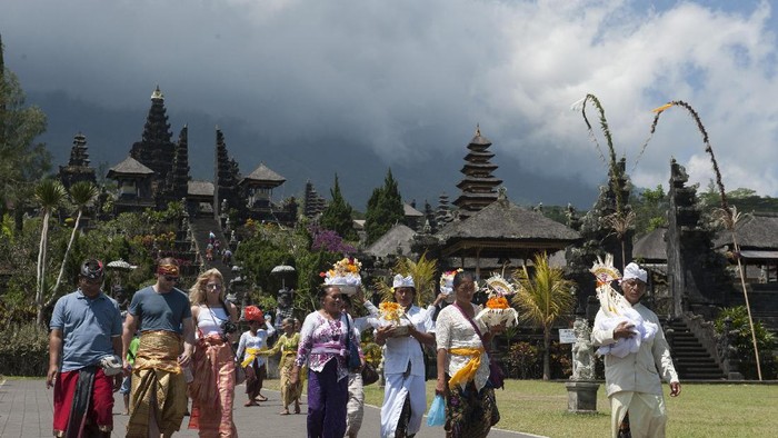 Sejumlah wisatawan beraktifitas di Pura Besakih yaitu Pura yang berada di kaki Gunung Agung, Karangasem, Bali, Selasa (19/9). Pusat Vulkanologi dan Mitigasi Bencana merekomendasikan zona larangan aktifitas hingga enam kilometer dari puncak Gunung Agung menyusul meningkatnya aktifitas gunung tertinggi di Bali itu hingga pada level siaga. ANTARA FOTO/Nyoman Budhiana/pd/17.