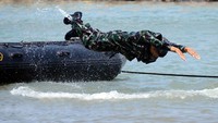 Seorang prajurit Korp Marinir terjun ke laut untuk menaklukkan rintangan dalam gladi parsial demo tempur matra laut. (Dispen Kormar).