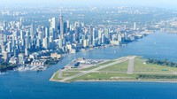 Di Billy Bishop Toronto City Airport, Kanada punya bandara yang pemandangannya kota Toronto dari seberang pulau. Sekitar bandara pun dipenuhi rumput hijau yang asri (Privatefly)