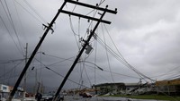 Seorang petugas polisi berjalan di sebelah instalasi listrik yang rusak di Guayama, Puerto Riko. (REUTERS/Carlos Garcia Rawlins)