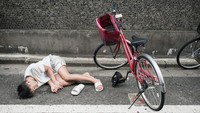 Gimana ya rasanya tidur di atas jalan dengan pakaian seadanya? Pria ini tampaknya sudah benar-benar mabuk. Sampai sendalnya masih terpakai sebelah. Foto: Lee Chapman