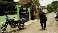 Rumah berpagar tembok warna hijau dan berpagar besi warna hitam itu terlihat sepi.