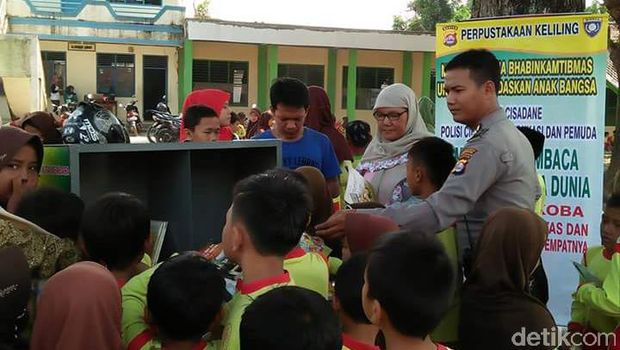 Bripka Wahyudin berkeliling dari sekolah ke sekolah agar anak-anak gemar membaca.