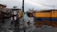Orang-orang menikmati saat di jalan yang banjir setelah daerah tersebut terkena Badai Maria di kota Catano, sebelah barat daya San Juan, Puerto Riko. (REUTERS/Alvin Baez)