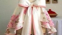 Apron setengah bagian ini hanya untuk melapisi bagian bawah saja. Terdiri dari rok klok tumpuk dengan paduan warna bunga dan pita besar di punggung.Foto: Istimewa