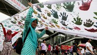 Usai membubuhkan cap tangan, warga langsung memajang spanduk tersebut berkeliling kawasan CFD.