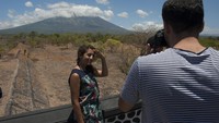 Dua wisatawan berfoto dengan latar belakang Gunung Agung, di Desa Batu Niti yang berjarak sekitar 12 kilometer dari gunung berstatus awas itu, Karangasem, Bali, Senin (25/9). (Foto: ANTARA FOTO/Nyoman Budhiana)