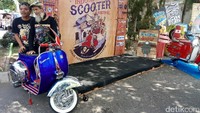 Pengunjung berpose dengan Vespa yang dipamerkan.