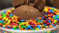 Bukan hanya es krim, dessert bentuk Mickey juga bisa ditemui pada Mickey Candy Apple. Lapisan cokelat cair dengan balutan permennya dijamin bikin ngiler. Mickey Candy Apple banyak ditemui di Disney World. Foto: Istimewa