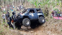 Panitia menarik mobil yang berhenti di tengah lintasan.