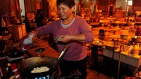 Para warga tidak masak di dalam rumah. Mereka punya ruangan besar yang digunakan sebagai dapur umum. Semua alat masak keluarga diletakkan di ruangan ini (Sheng Li/Reuters)