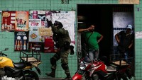 Seorang anggota angkatan bersenjata mengambil posisi dalam operasi setelah terjadi bentrokan antara kelompok narkoba di daerah kumuh Rocinha di Rio de Janeiro. (Dok. REUTERS/Bruno Kelly)