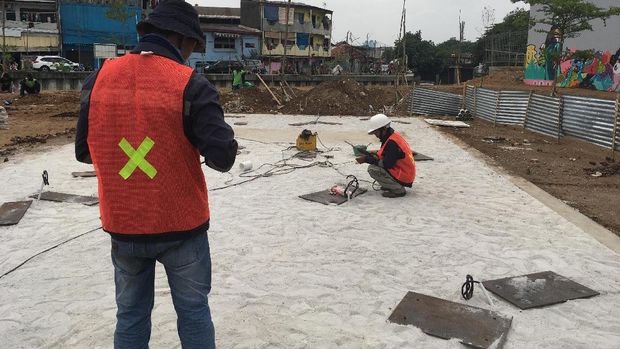 Para pegawai mempersiapkan lahan untuk pemasangan Tembok Berlin dan patung besi itu hari ini.