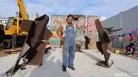 Seniman Teguh Ostenrik di depan karya Menembus Batas. Ia menggabungkan potongan tembok Berlin dengan pelat baja dengan bobot ratusan kilogram.