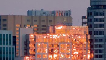 Ini bukan gedung yang terbakar, tapi momen saat matahari terbenam yang memantul di kaca gedung. (Foto: boredpanda)