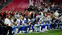 Sejumlah pemain Dallas Cowboys berlutut saat lagu kebangsaan AS dinyanyikan sebelum pertandingan melawan Arizona Cardinals di University of Phoenix Stadium