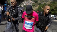 Polisi anti huru hara menahan seorang tersangka dalam operasi setelah terjadi bentrokan antara kelompok narkoba di daerah kumuh Rocinha di Rio de Janeiro. (Dok. REUTERS/Bruno Kelly)