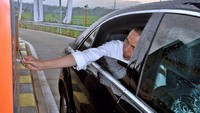 Dari kursi penumpang, Jokowi menjulurkan tangannya untuk menempelkan e-Toll ke mesin transaksi. Mobil pun melaju di tol yang diklaim terindah itu. (Agus Suparto/Setpres).