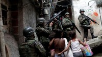 Tentara mengambil posisi dalam operasi setelah terjadi bentrokan antara kelompok narkoba di daerah kumuh Rocinha di Rio de Janeiro, Brasil. (Dok. REUTERS/Ricardo Moraes)