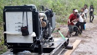 Petugas PLN menarik mesin melewati hutan di Pulau Pongok dan Celagen, Kabupaten Bangka. (PLN).