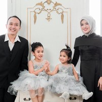 Aurora Kalista tampil cantik dengan dress hitam berbahan satin dove ketika pose untuk foto keluarga. Tema hitam-putih diambil kali ini. Gaya hijabnya terlihat simpel dengan cara yang konvensional hanya menggunakan satu jarum pentul di bawah dagu. Foto: Dok. Instagram @arurorakalista