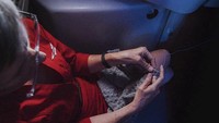 Salah satu pramugari Virgin America yang terbilang senior. Ia sesekali merajut sambil menunggu penerbangannya (Molly Choma Photography/CNN)