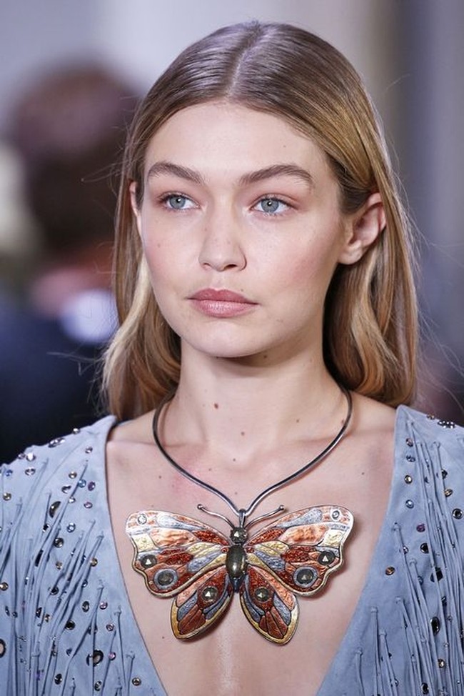 Gigi Hadid membawakan kalung statement berbentuk kupu-kupu dari Bottega Veneta. Aksesori yang sempurna untuk dipakai bersama baju dengan kerah V yang dalam. Foto: Dok. Elle