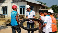 Beberapa petugas menyiapkan kabel yang akan dipasang di tiang listrik. (PLN).