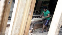 Pekerja menyelesaikan pembuatan kerajinan kayu.