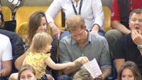 Emily mengambil popcorn milik Harry saat sang pangeran sedang berbincang dengan orang lain. Bukan cuma sekali, bocah berusia 2 tahun ini mengulangi perbuatannya saat Harry tak melihat.  (Foto: ITV News)