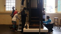 Mereka membersihkan ukiran kayu yang ada di museum.