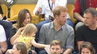 Bocah imut bernama Emily Henson ini diam-diam mencuri popcorn yang ada di pangkuan Pangeran Harry. (Foto: ITV News)