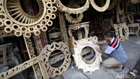 Seorang pekerja tengah membuat kerajinan kayu di Jakarta.