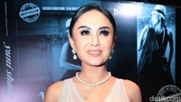 Yuni tampil dengan gaun yang dipadukan dengan celana putih panjang. Pool/Ismail/detikFoto.