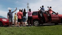 Warga berhenti di jalan raya di dekat tower pemancar sinyal untuk mencari sinyal untuk telepon seluler mereka di Dorado, Puerto Riko.