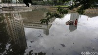 Seorang pekerja membersihkan sampah di Waduk Melati, Tanah Abang, Jakarta Pusat, Rabu (27/9).