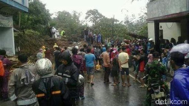 material berupa tanah, bebatuan dan pepohonan menutup badan jalan