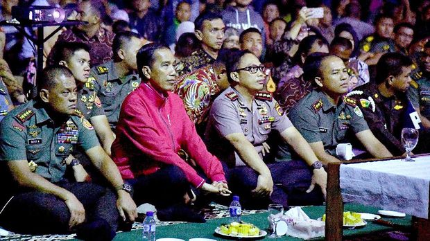 Presiden Joko Widodo (kedua kiri) didampingi Gatot Nurmantyo, yang saat itu masih menjabat Panglima TNI (kiri), menonton film G30S/PKI, di lapangan tenis indoor Markas Korem 061 Suryakencana Bogor, Jawa Barat, Jumat (29/9) malam.