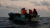 Setelah memakai jaket pelampung, mereka menanti untuk dipindahkan ke kapal yang lebih besar