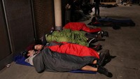 Warga tidur menggunakan alas dan selimut hingga sleeping bag di lapangan dekat sebuah sekolah yang rencananya digunakan sebagai TPS (Foto: REUTERS/Susana Vera)