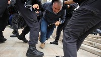 Namun situasi memanas. Tampak seorang pria ditarik oleh petugas di luar TPS di Sant Julia de Ramis (Foto: REUTERS/Albert Gea)