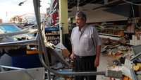 Pemilik supermarket di depan toko yang menyisakan kerusakan akibat Badai Maria.  