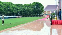 Jokowi tampak mengenakan setelan jas warna biru dongker dengan dasi warna merah.