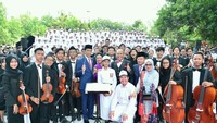 Jokowi, Iriana, JK, dan Mufida Kalla kemudian berpose dengan para pemain orkestra dan audabe. Jokowi tampak memegang tongkat dirigen