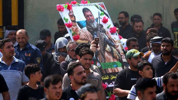 Para pelayat Irak menyimpan potret Abu Tahsin al-Salhi saat pemakamannya di dekat kota selatan Basra