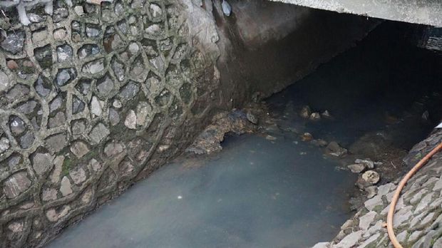 Mayat bayi itu menyangkut di bebatuan yang berada di saluran air.