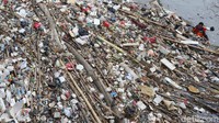 Petugas mengangkat sampah yang terbawa arus sungai di Pintu Air Manggarai, Jakarta, Senin (2/10).