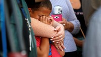 Seorang anak tampak menangis saat berdoa untuk para korban. REUTERS/Las Vegas Sun/Steve Marcus.