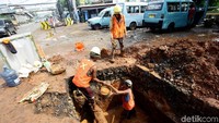 Pekerja tampak sibuk menggali lubang baru sementara lubang yang lama saja belum ditutup.
