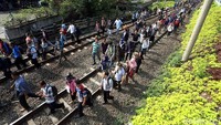 Sebagian penumpang memilih melompati pagar rel.